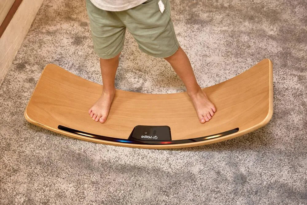 Balance board toy with glowing center panel and rounded wooden platform