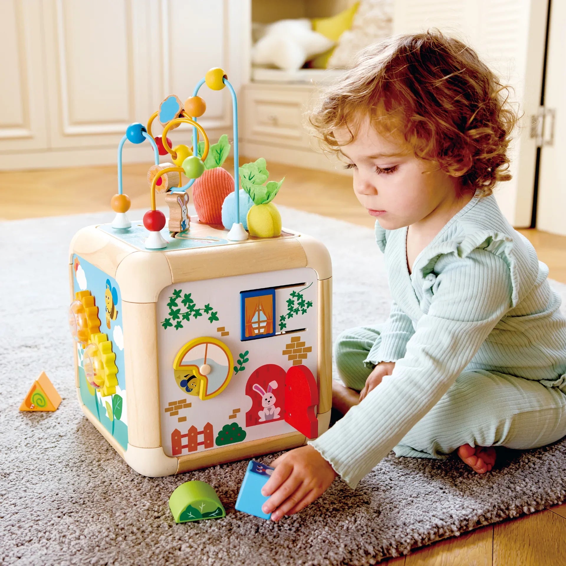 Carrot activity cube with colorful gears and panels for toddler play