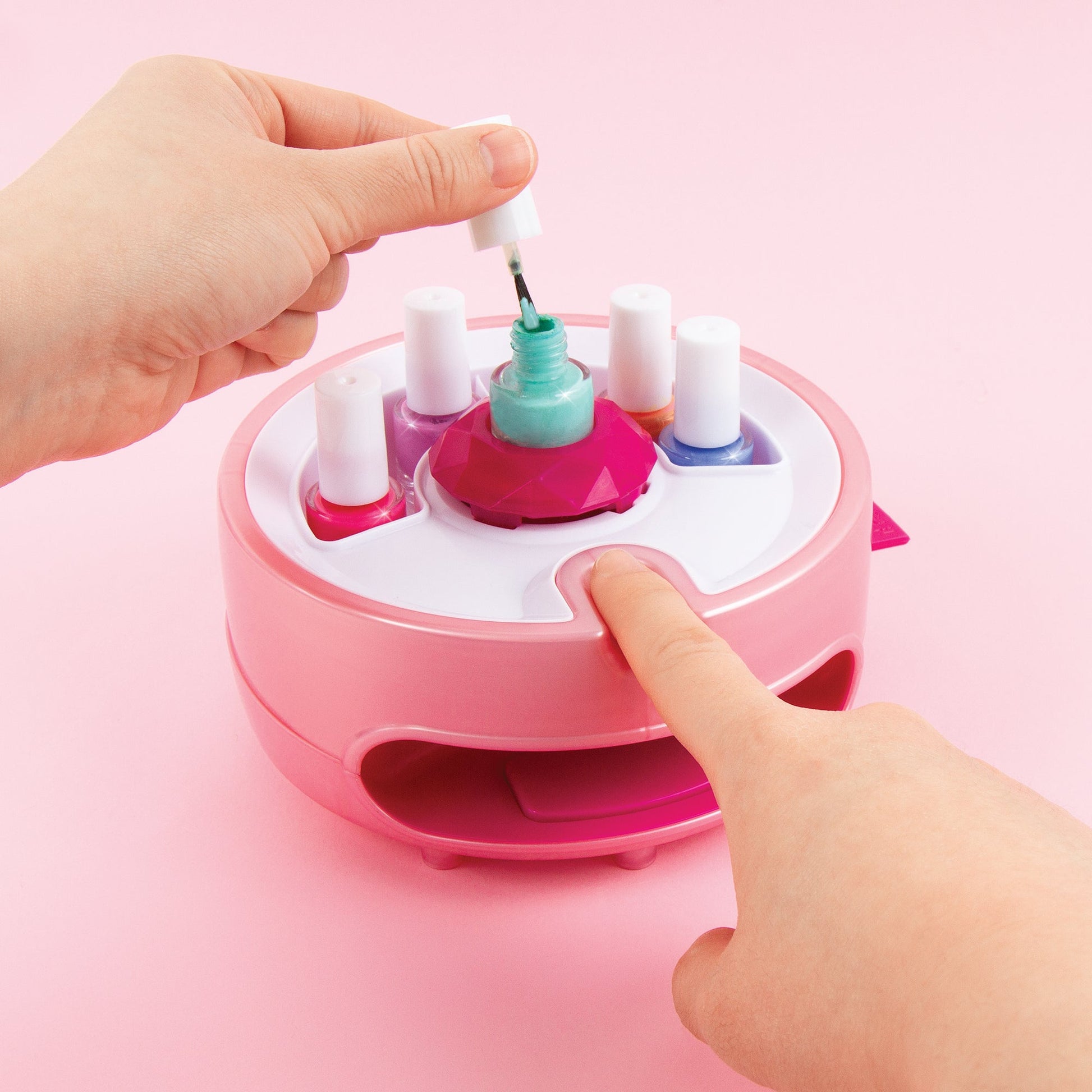 Hands placing a polish bottle in the pink Light Magic Nail Dryer