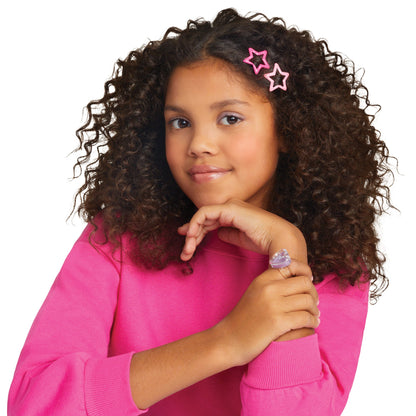 Girl with curly dark hair wearing two pink star hair clips and a pink top