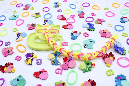 Colorful Loomi-Pals dinosaur charms and rubber rings scattered across background