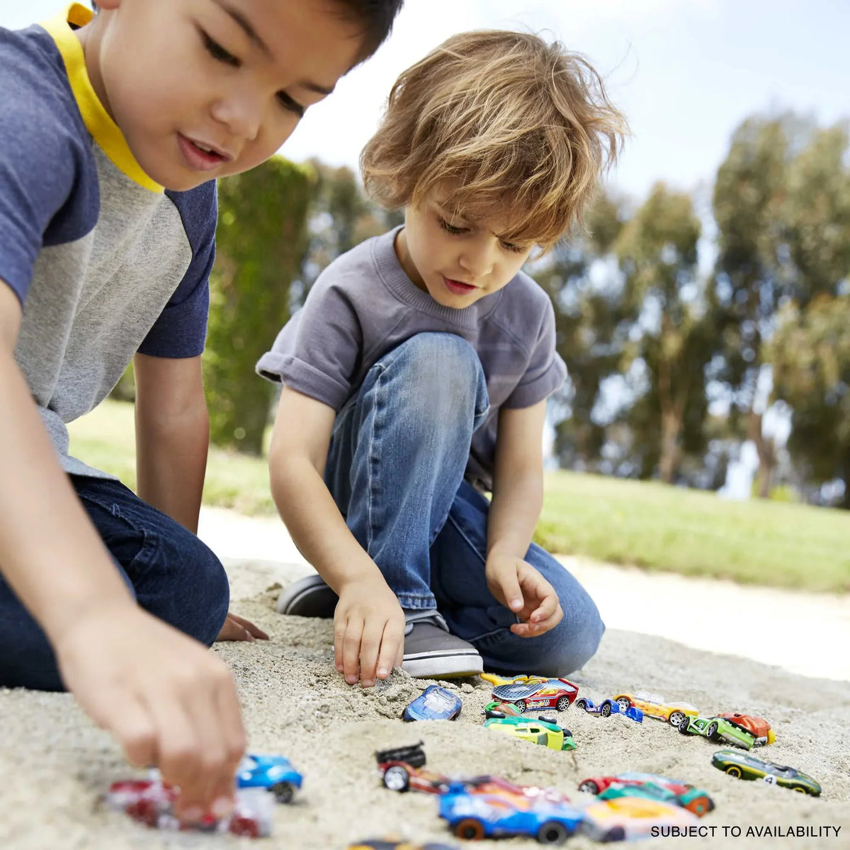 Colorful die-cast toy cars on a concrete path