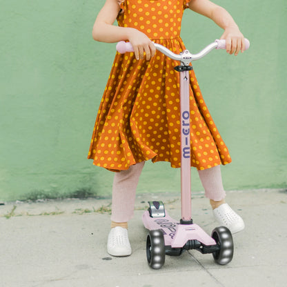 Pink LED scooter ridden by a child, showing wheels and handlebar
