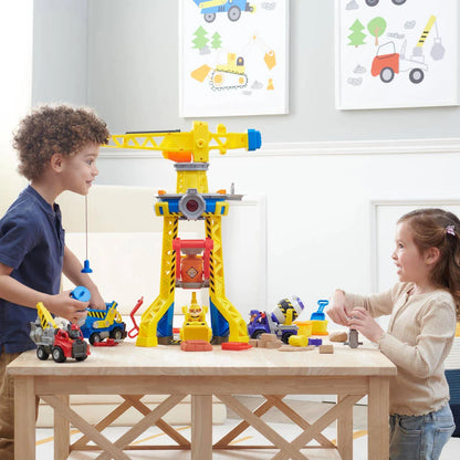Interactive yellow crane tower toy with blue base and orange accessories on a play table