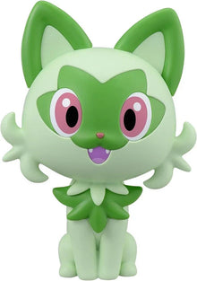 Sprigatito: figura verde y crema, orejas grandes, ojos rosas y mejillas sonrosadas