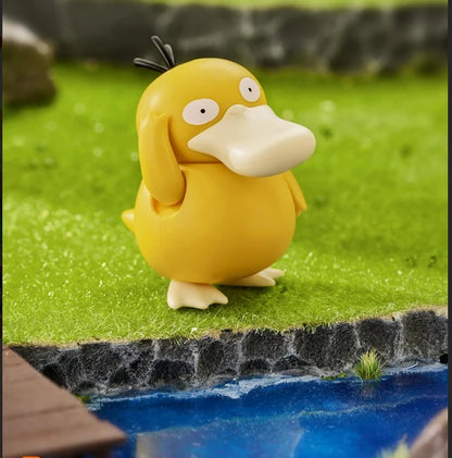 Psyduck character figure standing on rocky edge by blue water