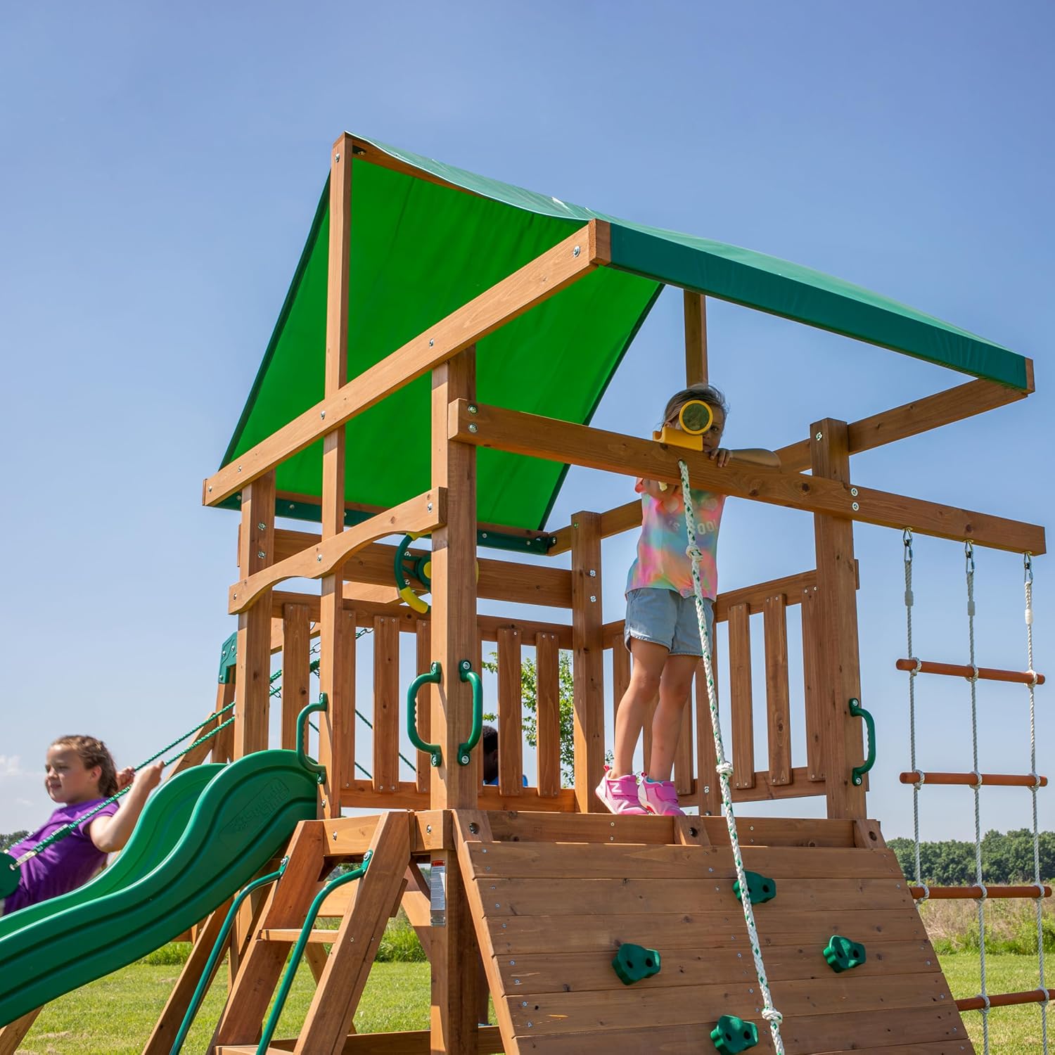 Holzspielset mit grünem Dach, Rutsche und Schaukelsitzen am Plattformbereich