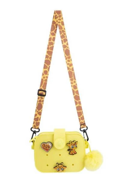 Yellow mini crossbody bag with adjustable giraffe-pattern strap, pom-pom and patches