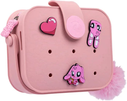 Pink mini bag with character face patches, heart accent, and fuzzy pom-pom detail