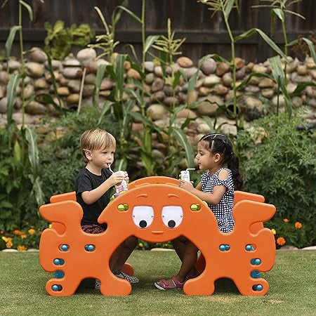 Orange ghost picnic table with green top and curved handle-like sides