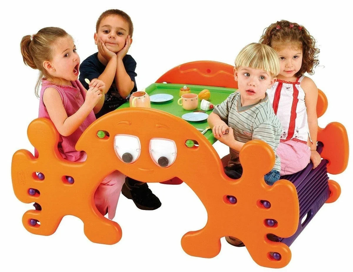 Orange plastic picnic play table with ghost face cutouts and round activity holes