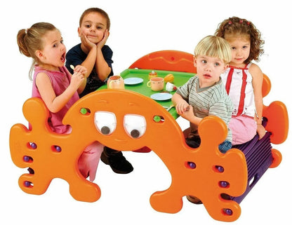 Orange plastic picnic play table with ghost face cutouts and round activity holes