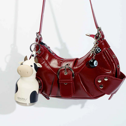 Mini animal water bottles clipped to a red leather-look bag, cow and cat designs.