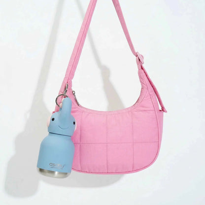 Pink crossbody bag with blue bunny mini water bottle keychain hanging
