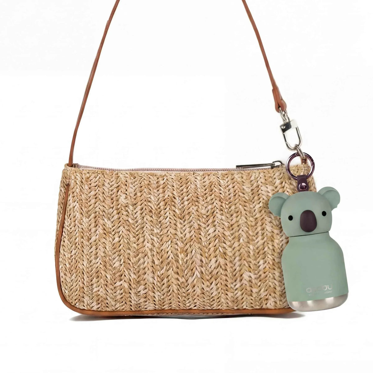 Green koala mini water bottle keychain attached to a woven crossbody bag