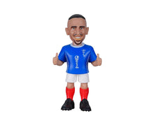 Football player figure in blue jersey, white shorts, red socks, black boots, fists raised