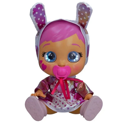 Baby doll seated with pink bunny-ear hood, heart accents, and dot-pattern outfit