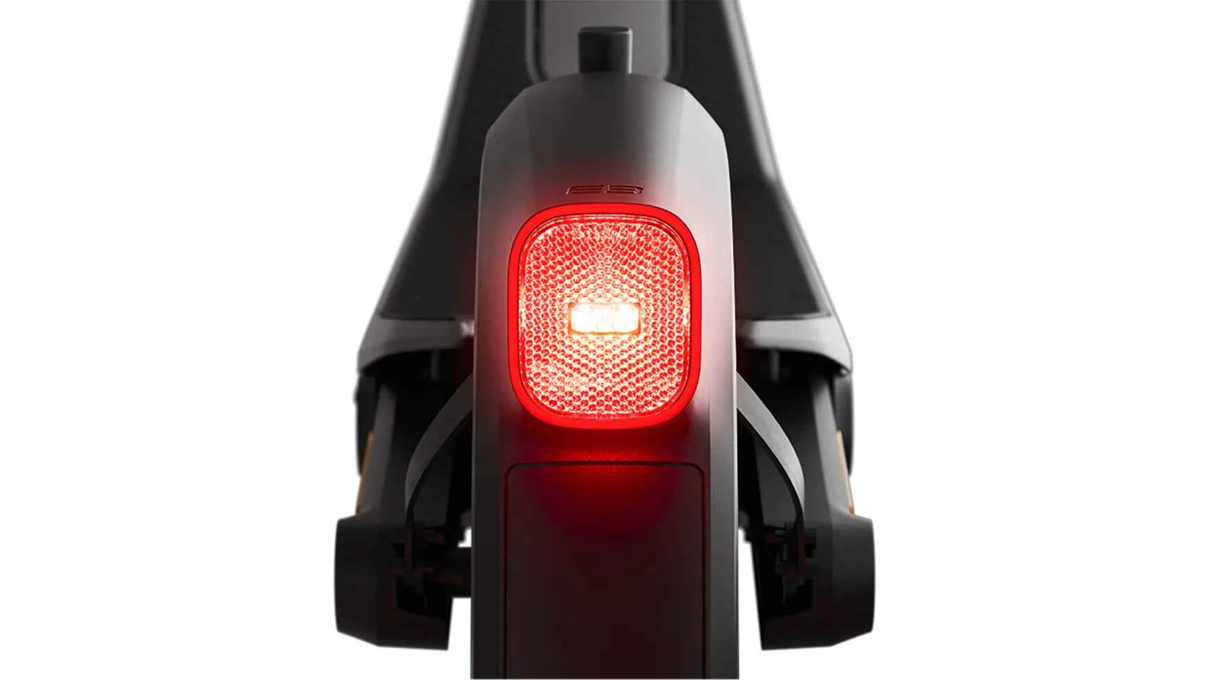 Rear light of dark electric e-scooter glowing red