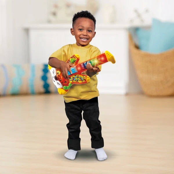 Colorful toy rock guitar for kids with animal graphics, held by a child