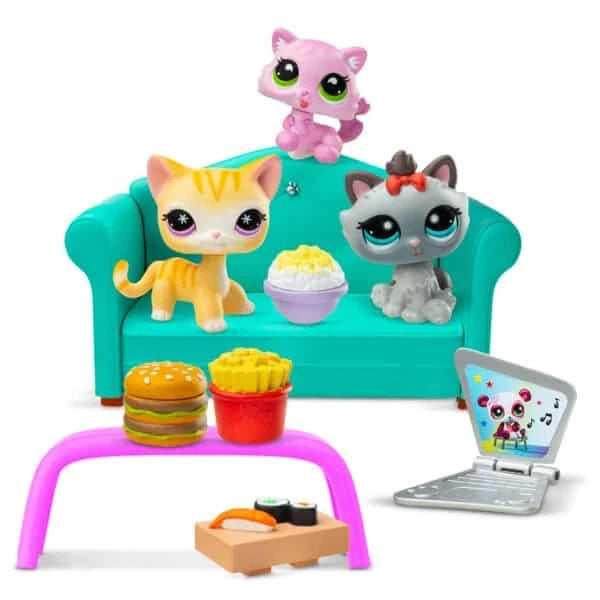 Diner Dash play set featuring teal sofa, pink and gray cat figures, food items, and laptop
