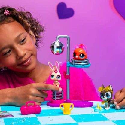 Disco pet playset with character figures and child hands playing beside the stand