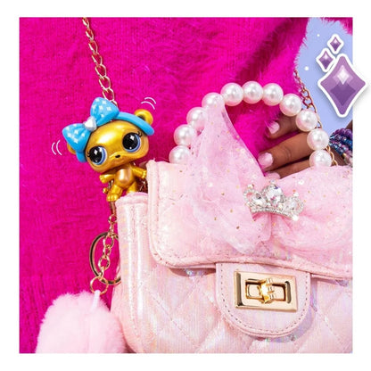 Pink pet purse accessory with pearl necklace and dangling pet keychain figurine