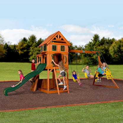 Wood playhouse swing set with green slide and multiple hanging swings