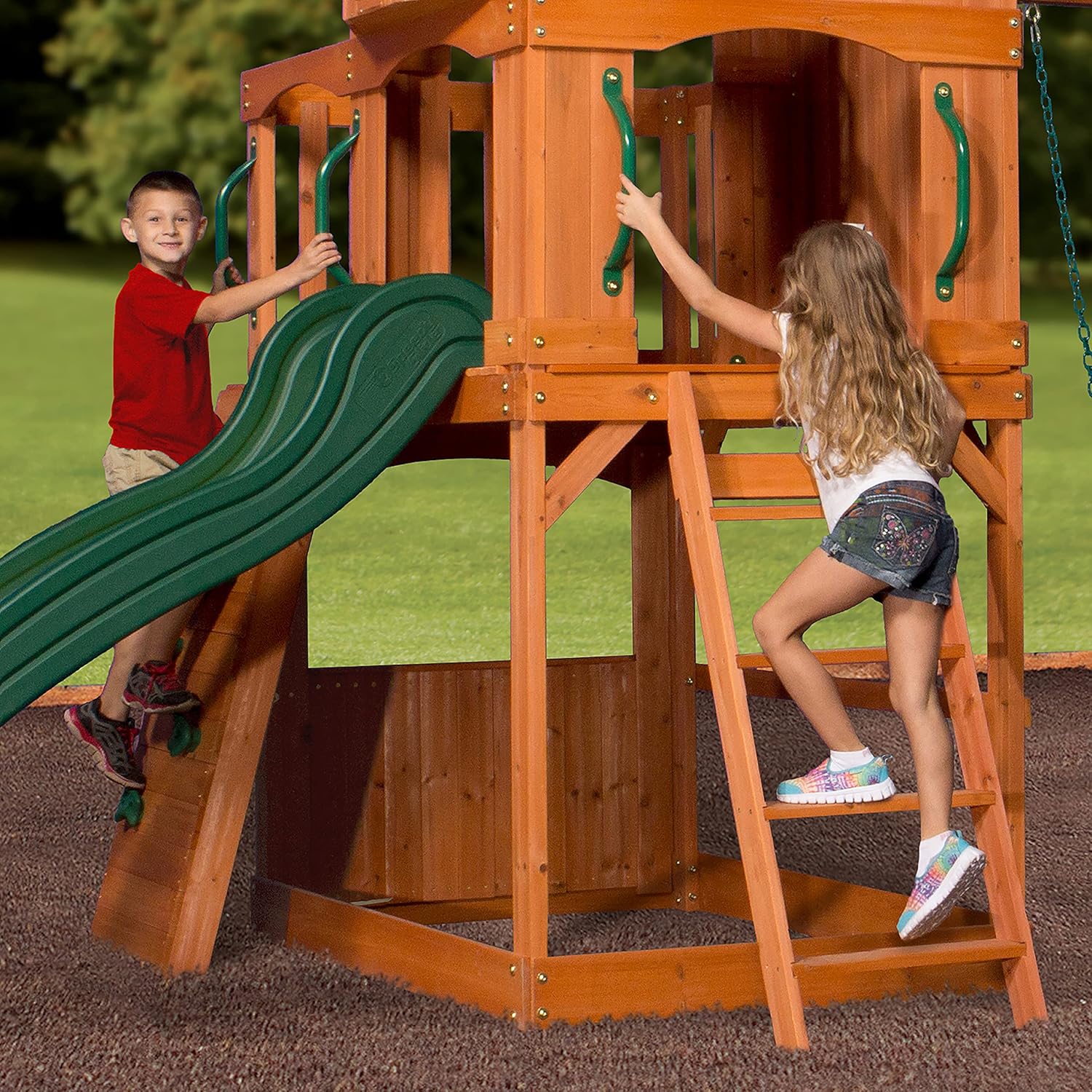 Front view of wood playhouse swing set with green slide and swing chains