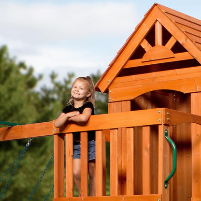 Wood playhouse roof and balcony edge with green curved handrail