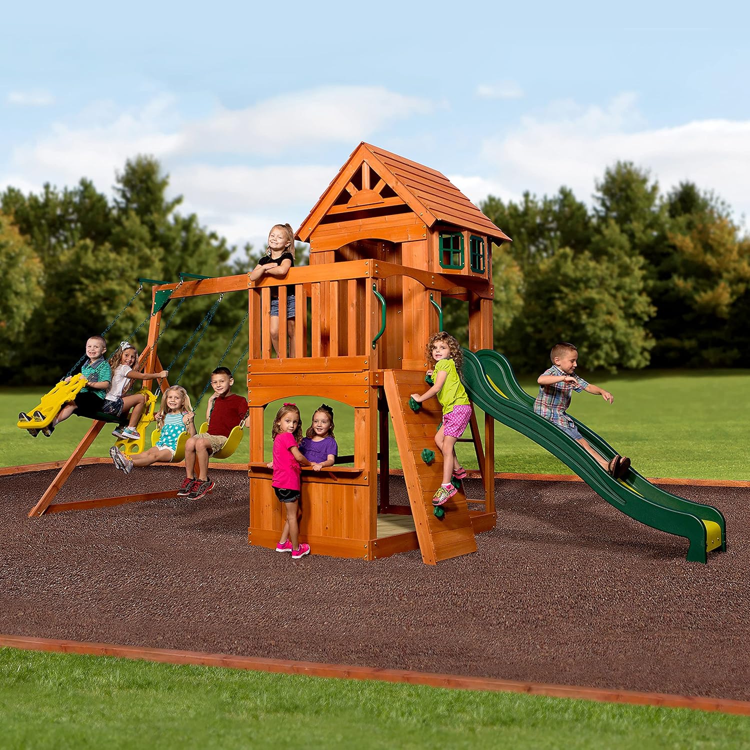 Wood playhouse swing set with green slide, platform swings and stairs