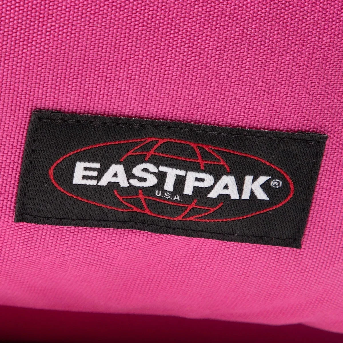 Eastpak logo patch on pink textured fabric