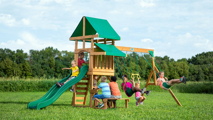 Angled view of cedar wood play tower with green slide and two rope swings