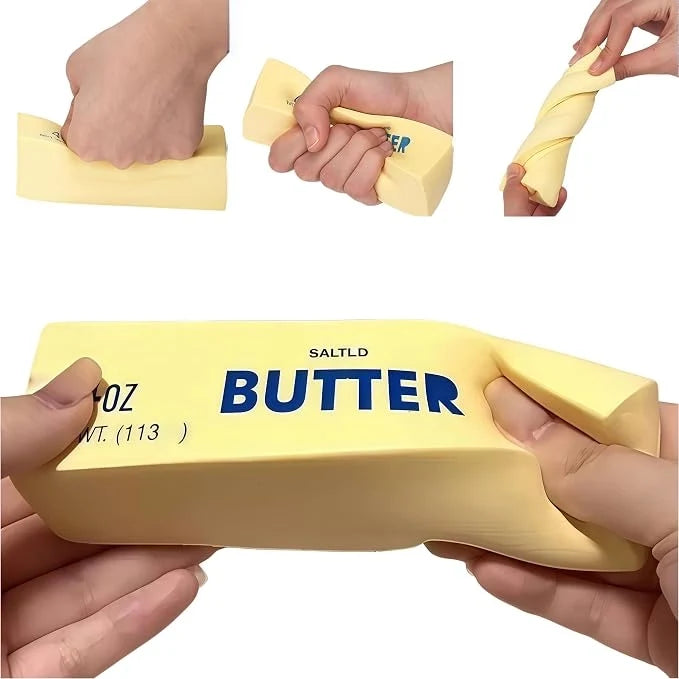 Butter-shaped squishy block held in hands, pale yellow with blue BUTTER and 4oz label