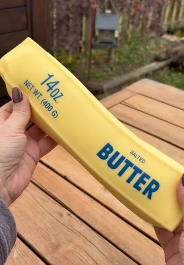 Large salted squishy butter bar packaging, yellow bar with blue 'BUTTER' label, held