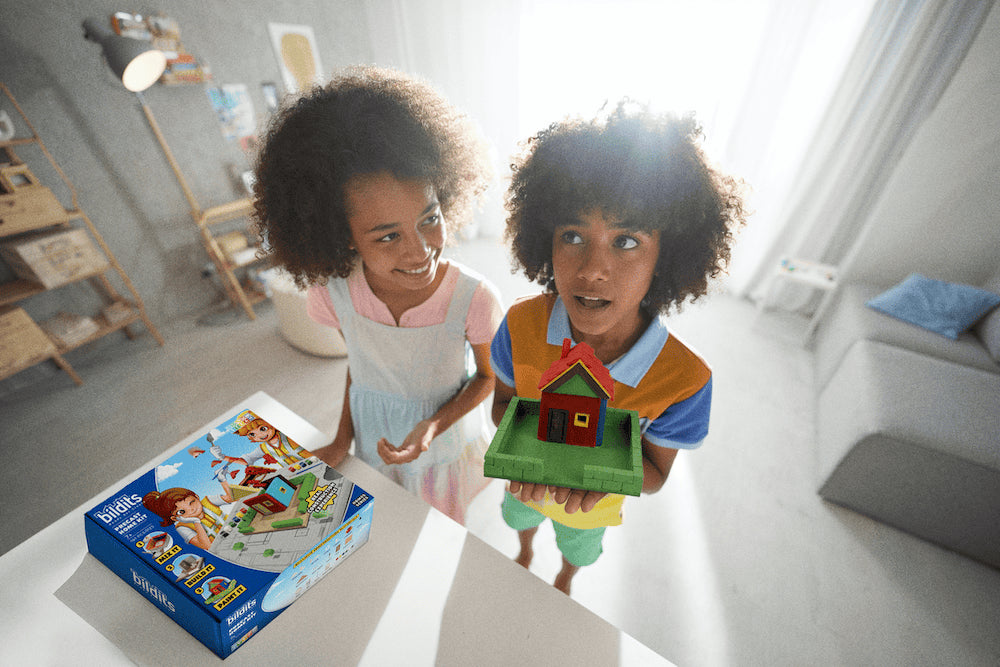 Precast Home Kit house model with two kids holding it and the kit box nearby