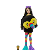 Toucan Cutie Reveal Puppe mit lila Haarschmuck, schwarzem Plüschoverall, gestreiften Leggings