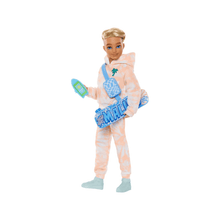 Muñeco Ken posable con mono beige, peto azul y botas celestes; sostiene un accesorio