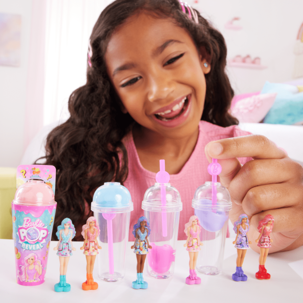 Child holding Pink Lemonade mini reveal cups with tiny doll figures