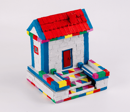 Brick house model with blue walls, red roof, colorful accents, and patio base