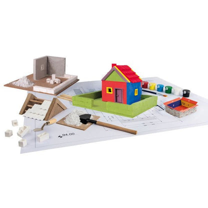 Precast Home Kit pieces laid out: house parts, tools, and building plan