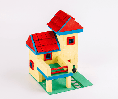 Assembled modern dollhouse with cream walls, red roof, blue edges, and green base