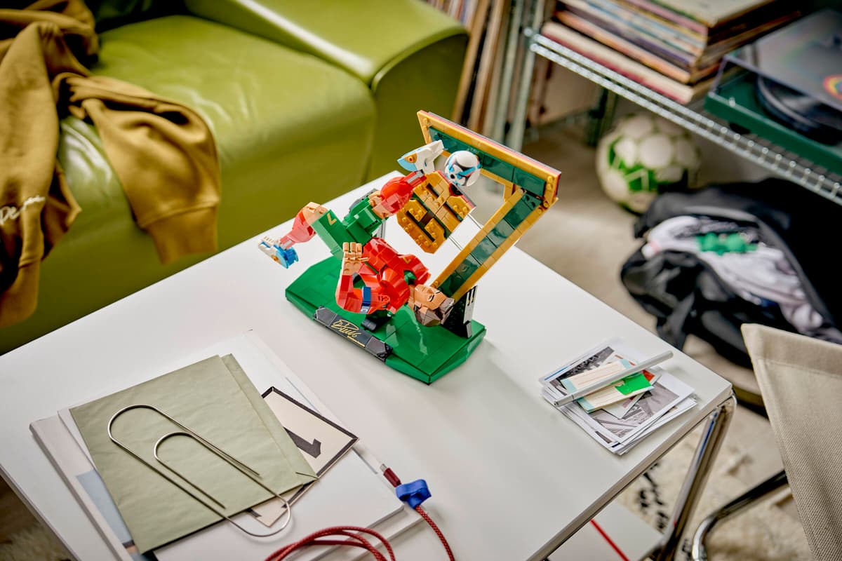 LEGO soccer legend figure build on a green base among small pieces on a table