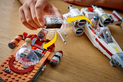 Hand assembling Luke's Landspeeder LEGO model with red and white parts