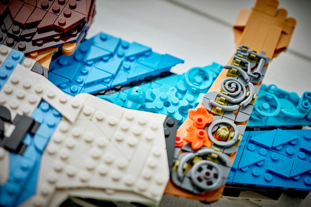 Close-up of brick torso and arm parts with blue, white, and orange mechanical elements