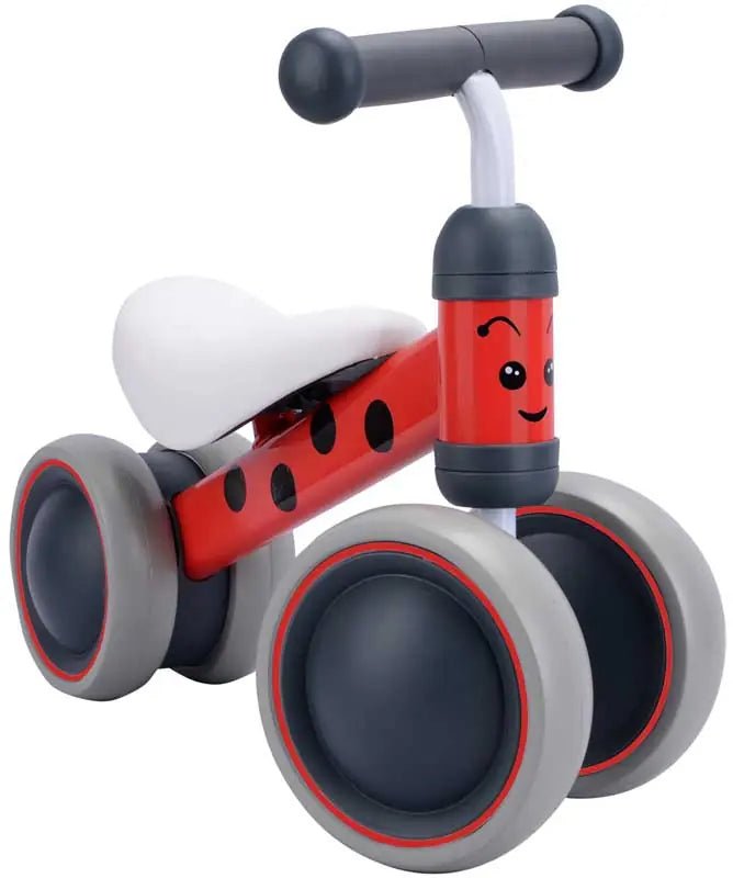 Baby balance bike with red ladybug body, white seat, and gray wheels