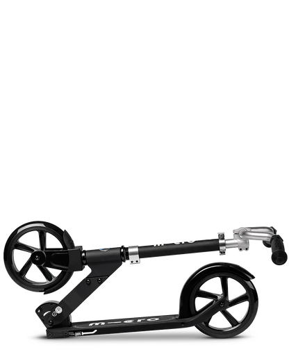 Black folding kick scooter with black wheels, black deck, and silver handlebars