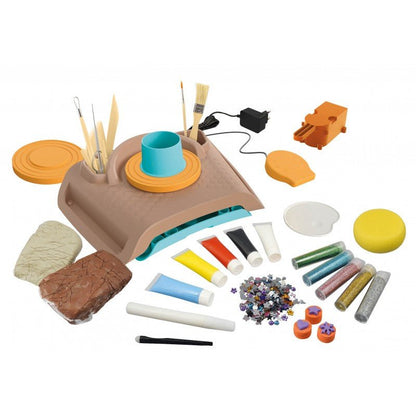 Pottery kit accessories with tools, clay pieces, colored paints, and shaping discs