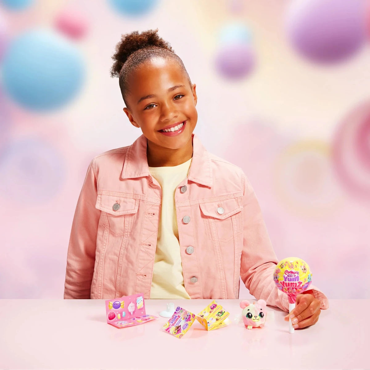 Child holding a Yum Yumz plush while the yellow S3 single pack sits on the table