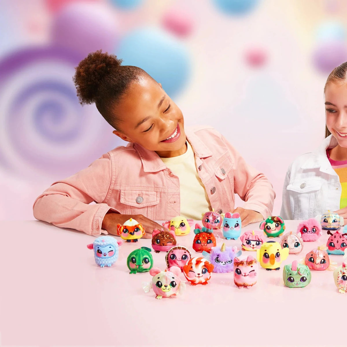 Small colorful Yum Yumz plush figures scattered on a tabletop in front of a child