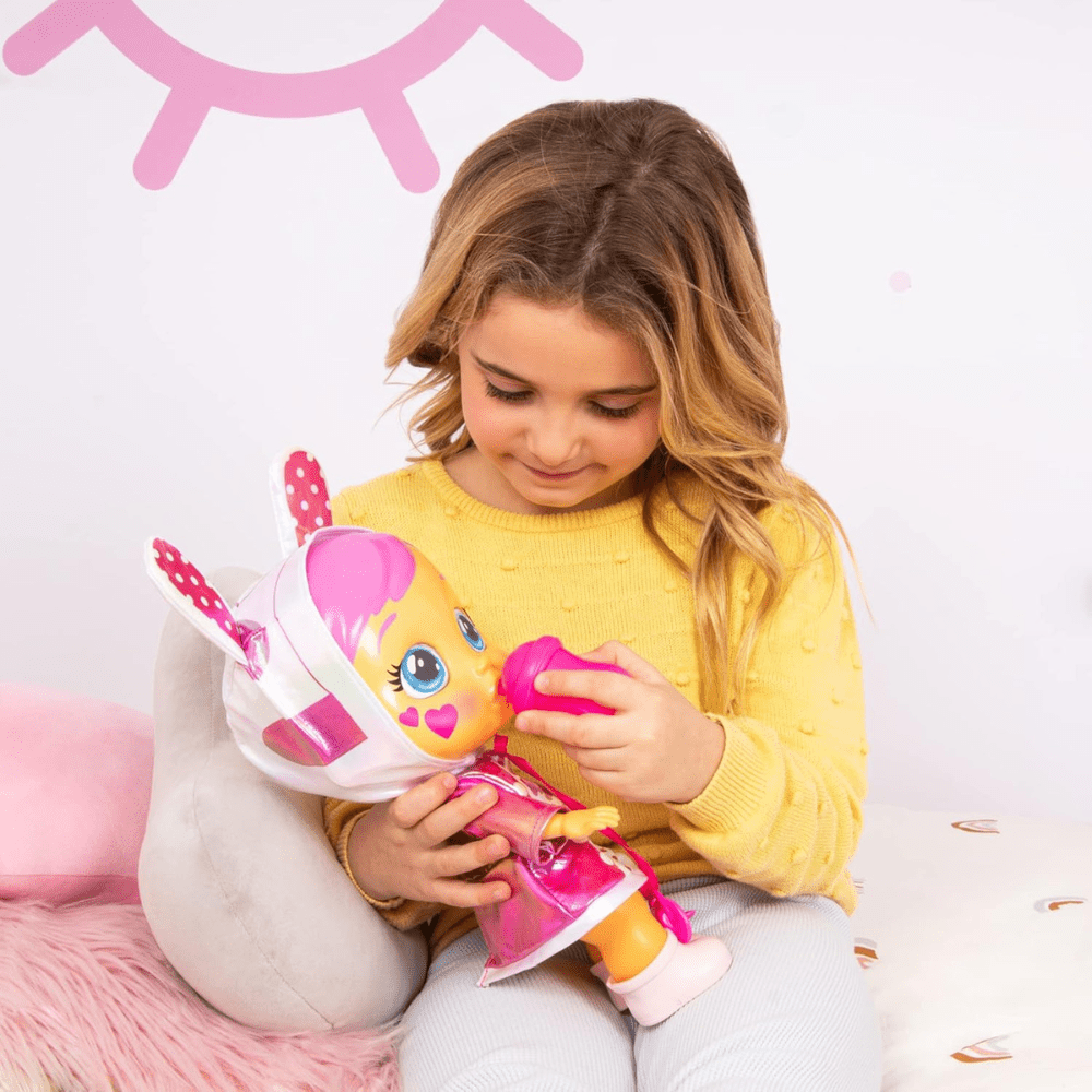 Baby doll with pink bunny hood and yellow sweater top, held with mini accessories